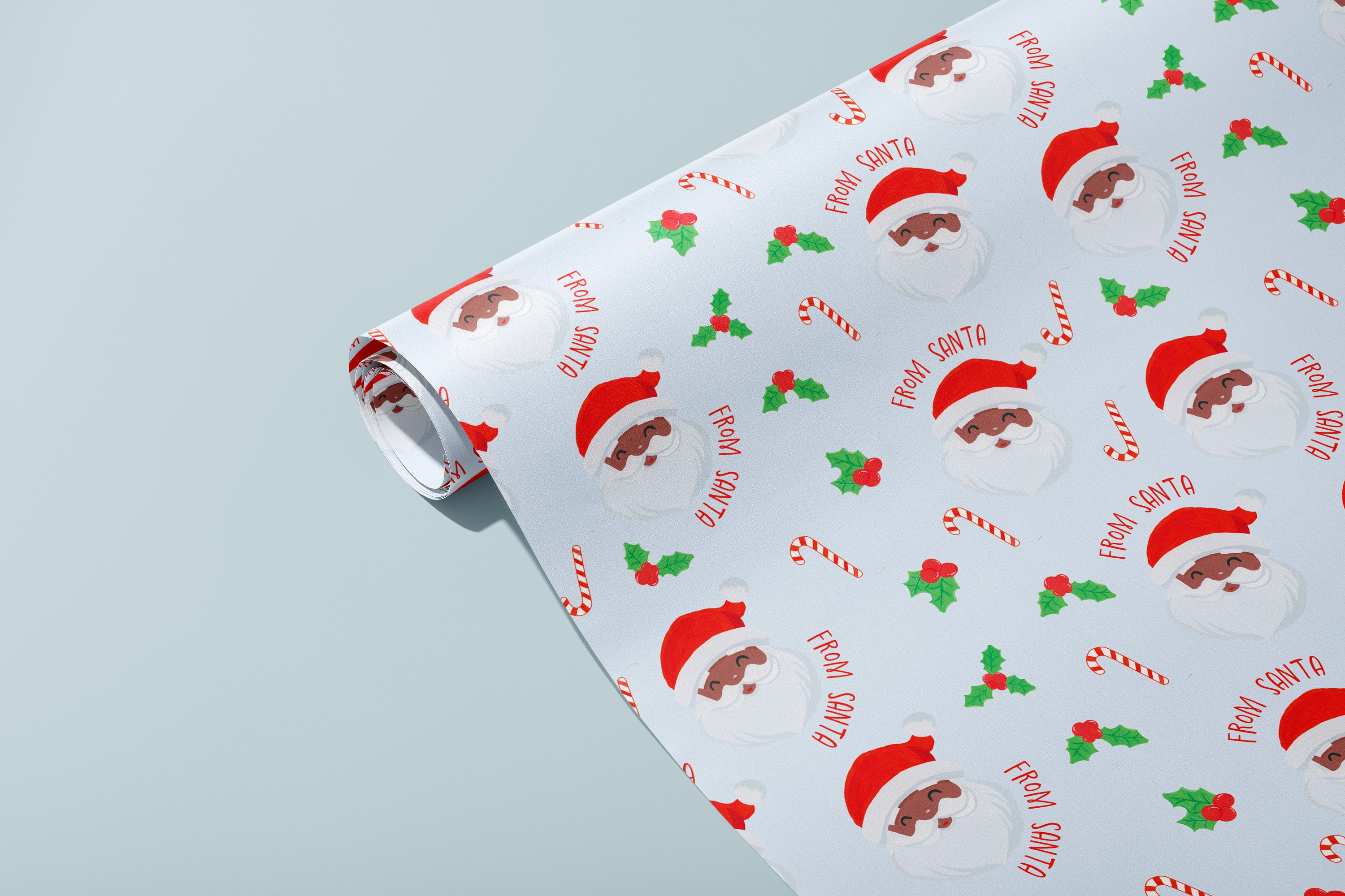 Roll of Christmas-themed wrapping paper with black Santa Claus faces and candy cane designs on a light blue background.