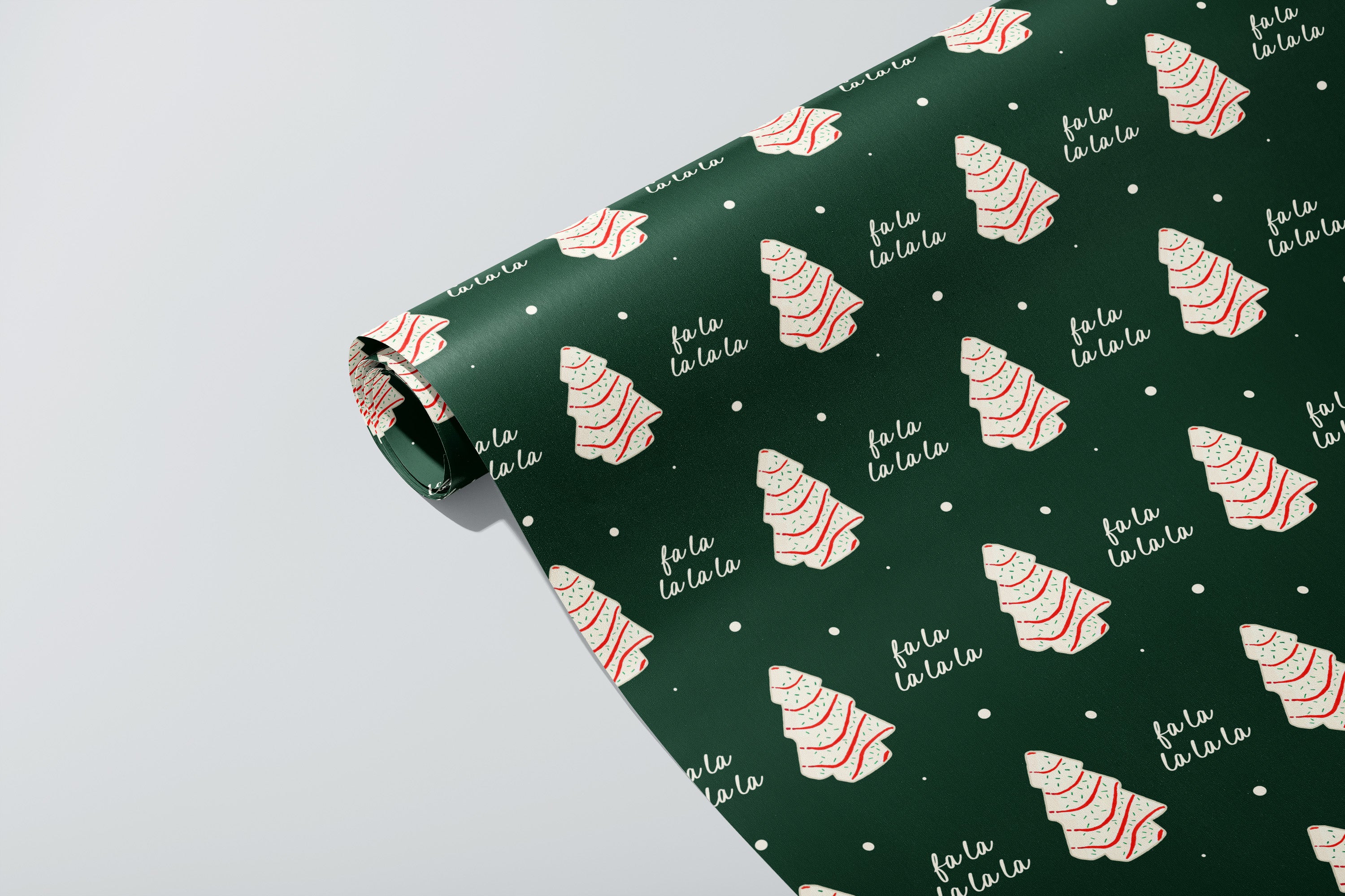 Roll of green wrapping paper with Christmas tree and 'fa la la' pattern on a white background